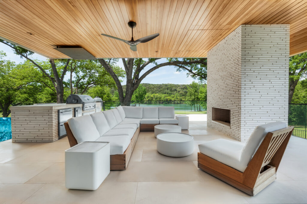 The outdoor entertaining lounge at The Legacy of Lake Austin features a built-in grill and fireplace