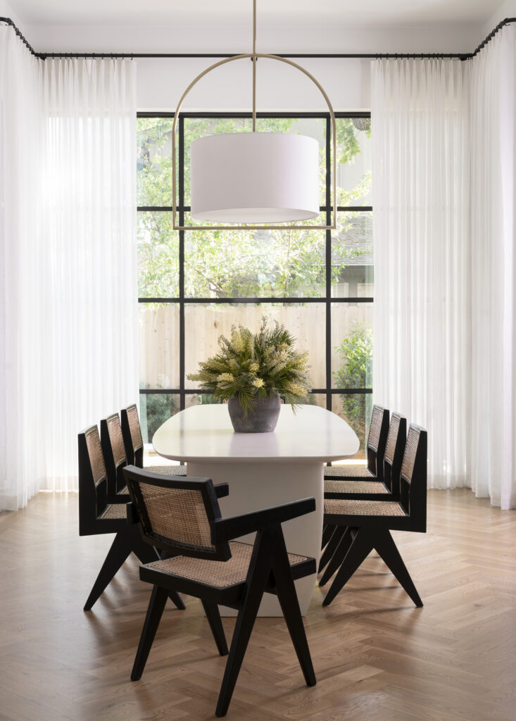 Dining room featuring a white table and a bouquet of flowers on the table.