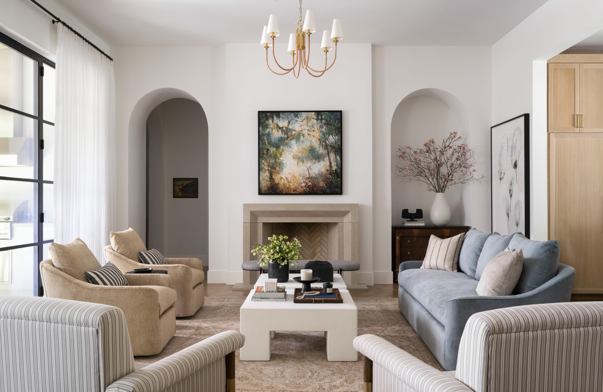 Living room with a white coffee table, a small couch, and four plush chairs.