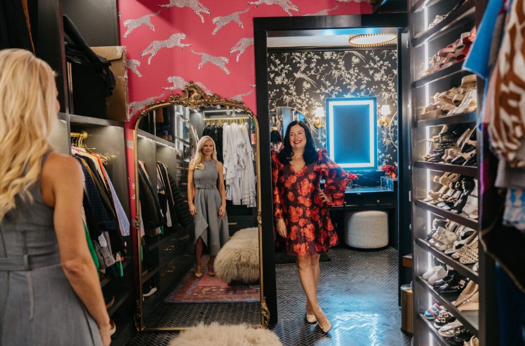 Brandy Fons and interior designer Jenny Mason in Fons' walk-in closet, wrapped in a Scalamandré print, with an adjoining vanity room featuring black and white floral wallpaper. (Photo Lemon Woman Photography)