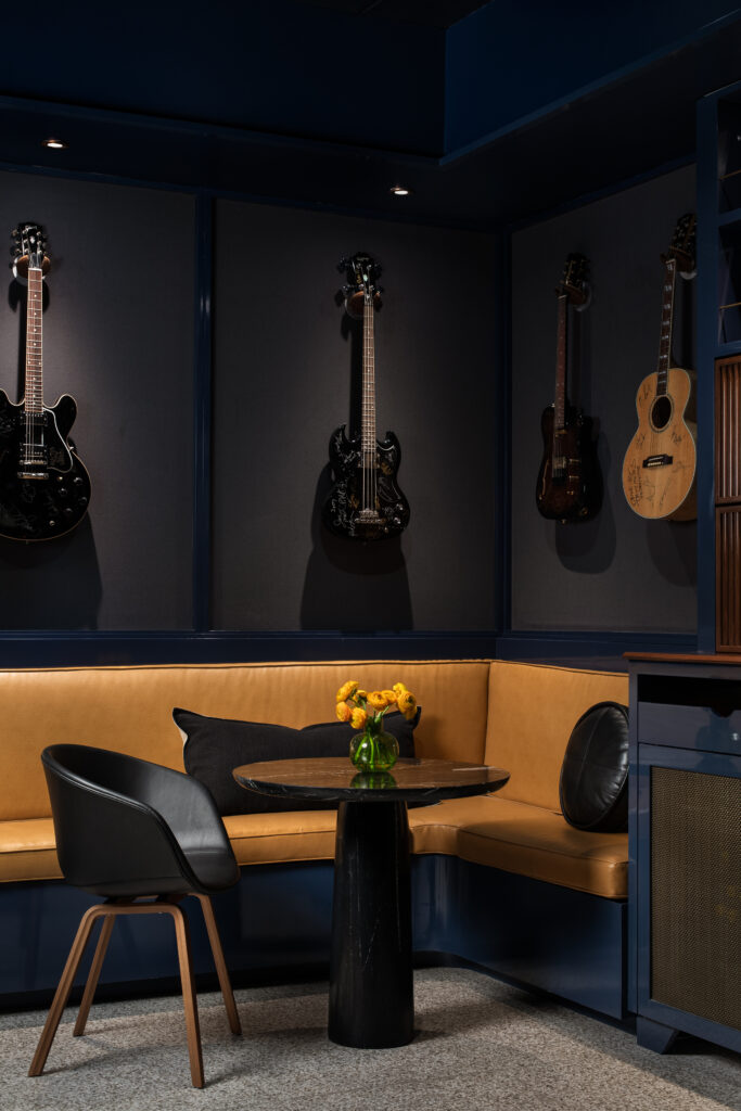 The Green Room at Austin PBS, redesigned by Britt Design Group, features lounge seating, a custom record console, and guitars on display in tribute to Austin’s music culture.