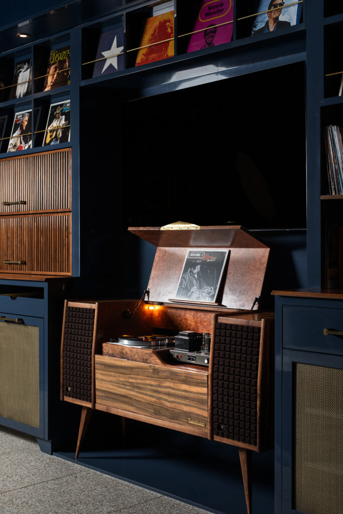 The Green Room at Austin PBS, redesigned by Britt Design Group, features lounge seating, a custom record console, and guitars on display in tribute to Austin’s music culture.