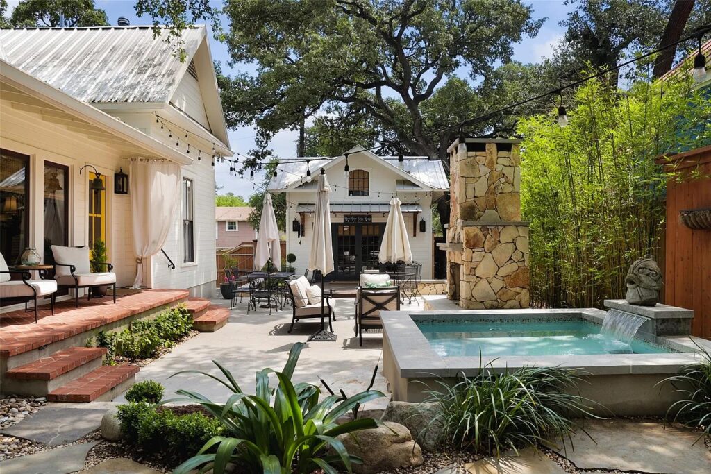 This Austin home has a courtyard style backyard with a fountain and entertaining spaces.
