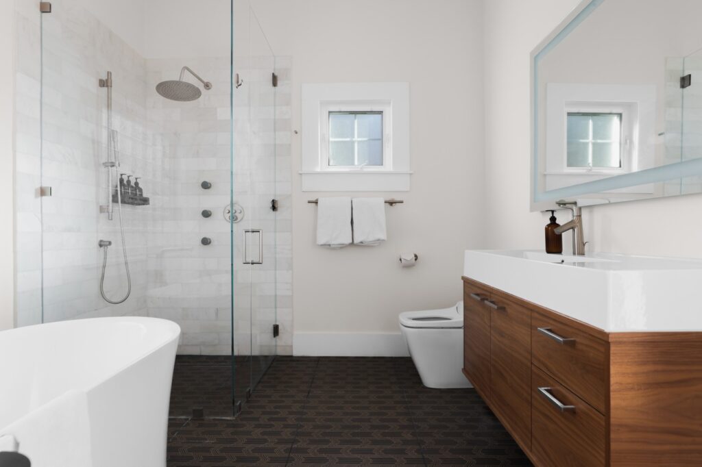 White bathroom with modern appliances and a dark tile flooring. (Photo courtesy of Moreland Properties)
