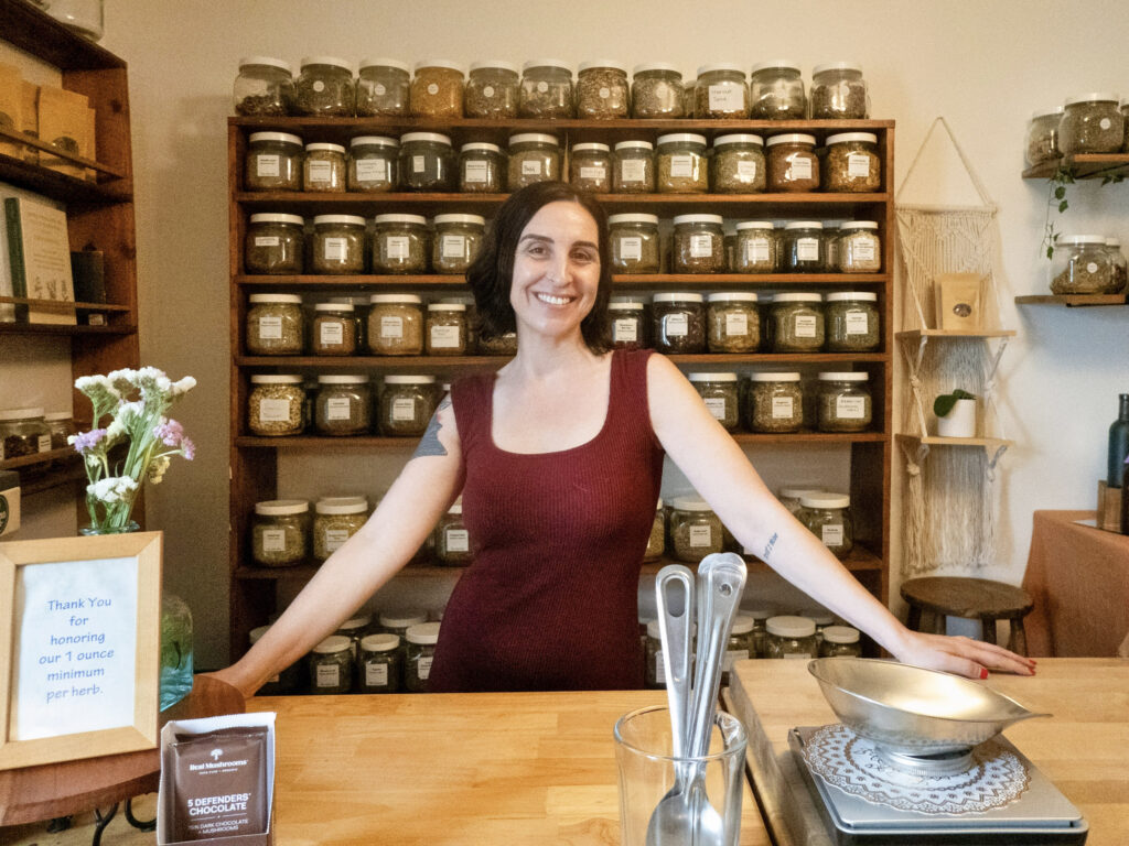 Meg Mundy, owner of The Herb Bar, stands behind the counter of the shop’s new Cherrywood location. (Photo by Natalie Grigson)