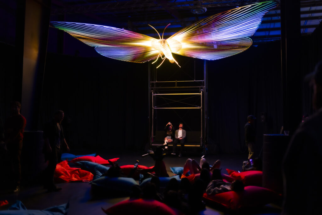 Visitors interact with Christopher Schardt’s “Mariposa,” a 26-foot butterfly sculpture