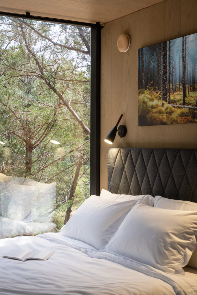 The cabin’s bedroom features functional, modern details like a reading light above the bed frame.