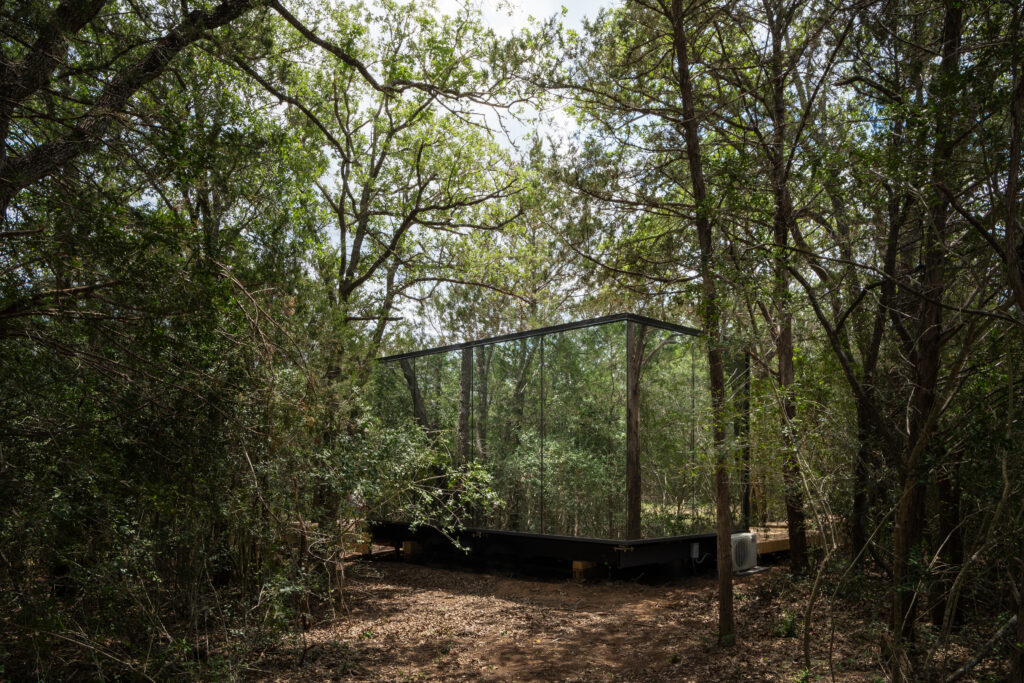 The mirrored cabins reflect the surrounding pines while offering modern, boutique-style accommodations about an hour from Austin.
