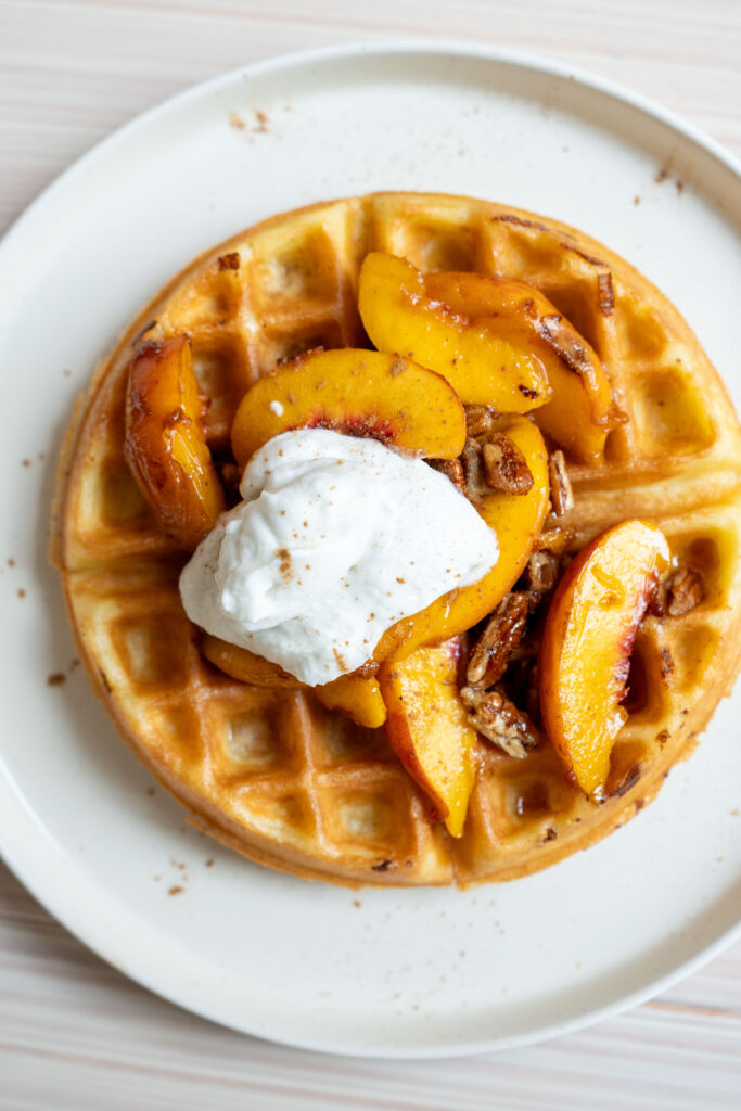 Maple pecan peach waffle topped with compote and coconut whipped cream.