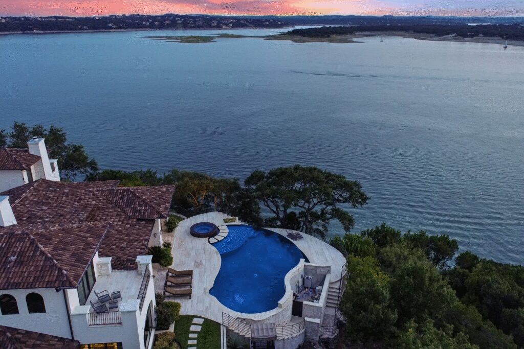 Built in 2012, the home features an infinity-edge pool, a grandfathered boat dock and tram, and expansive lake views from nearly every room.