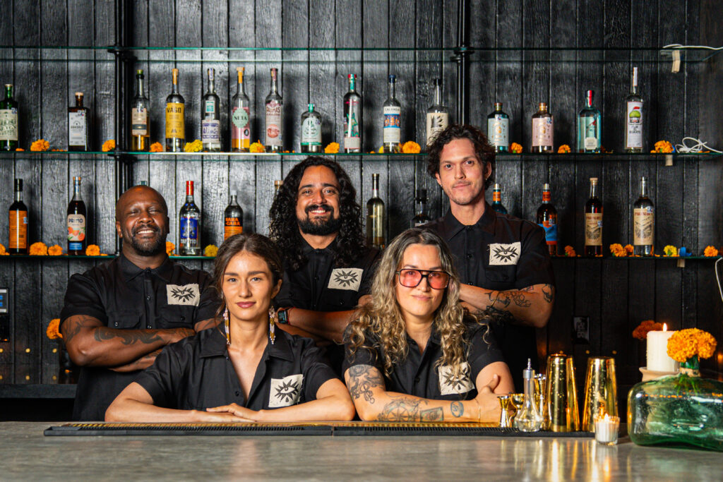 The La Mezca team smiles behind the bar of the East Austin mezcalería, which opened in October.