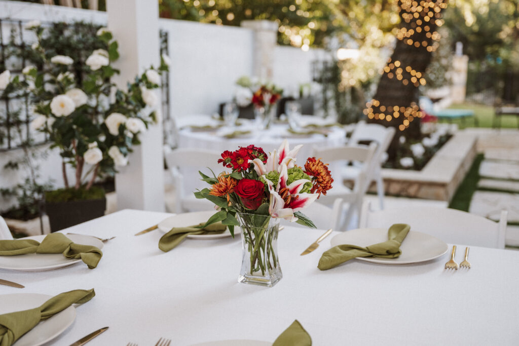 Dining tables are set with floral arrangements at the reception. (Photo by Christina Gleim)