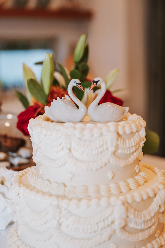 A multitiered, vintage-style cake from SusieCakes is topped with a pair of swans sourced from Etsy. (Photo by Christina Gleim)