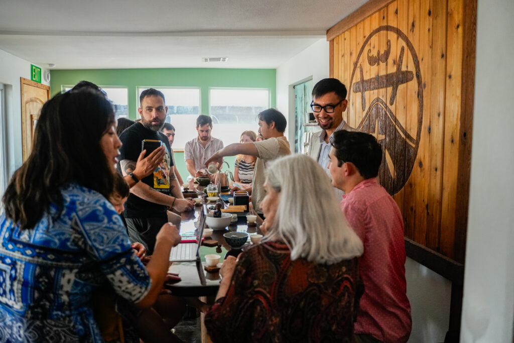 Guests sit shoulder to shoulder at a communal tea bar at West China Tea House.