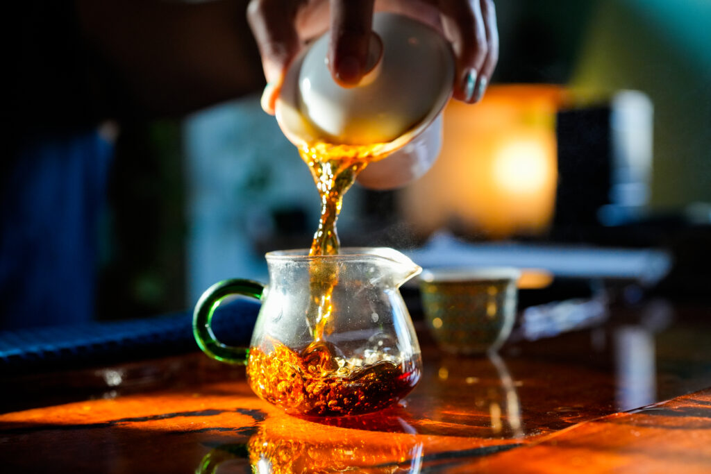 A server steeps loose-leaf tea in a lidded bowl before straining it into a fairness cup at West China Tea House in Austin, a traditional process designed to ensure equal strength in each pour.