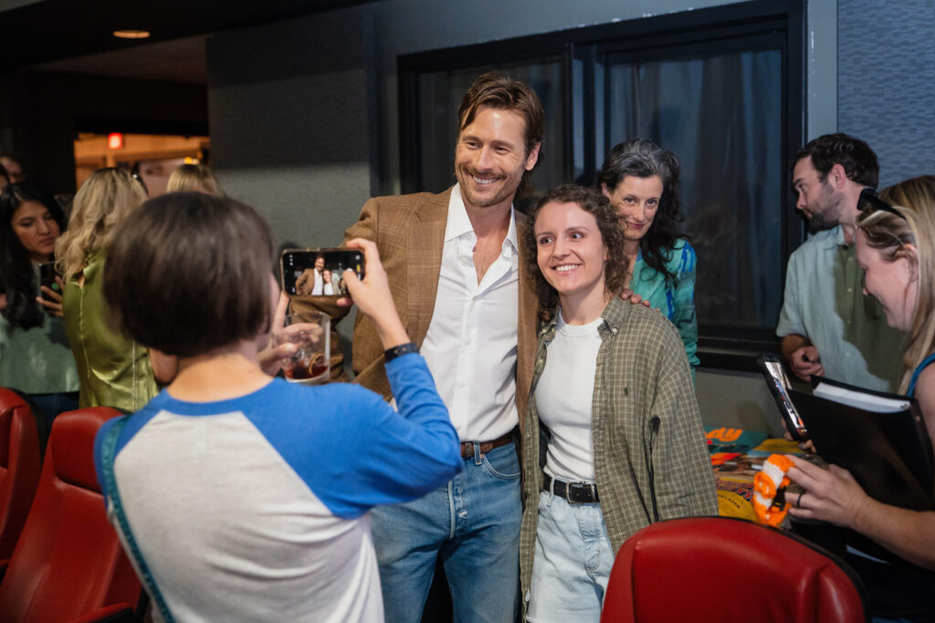 Glen Powell poses with a fan at the “Everybody Wants Some!!” 10th anniversary screening. (Photo by Lauren Slusher)