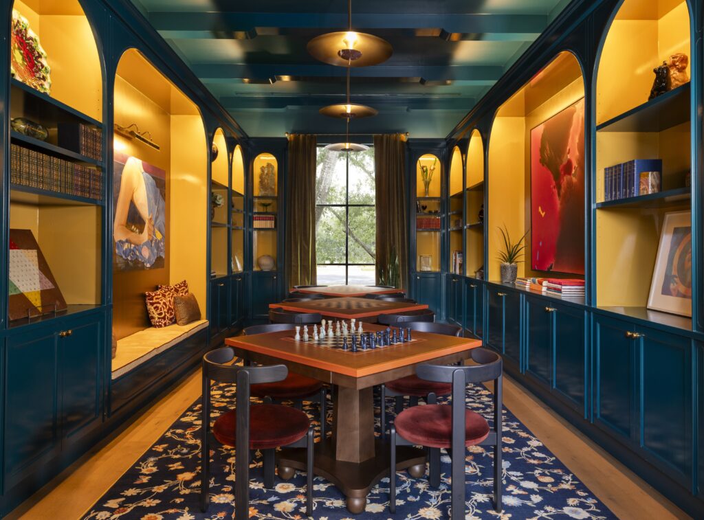 Hotel Daphne's library and game room with chess table and books in Houston.