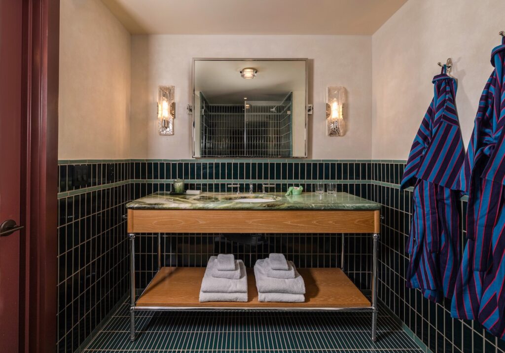 Bathroom with gorgeous green tiles and classic Bunkhouse robes