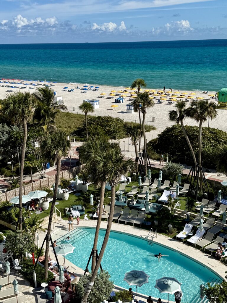 View of pool, palm trees and ocean from the balcony at Andaz Miami Beach.