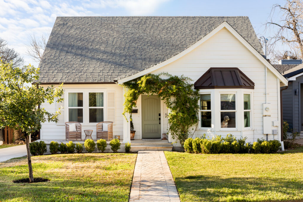 The front exterior of 1706 Wethersfield showcases classic curb appeal with layered greenery, inviting architectural details and a welcoming front porch. (Photo by Dillon Magnuson)