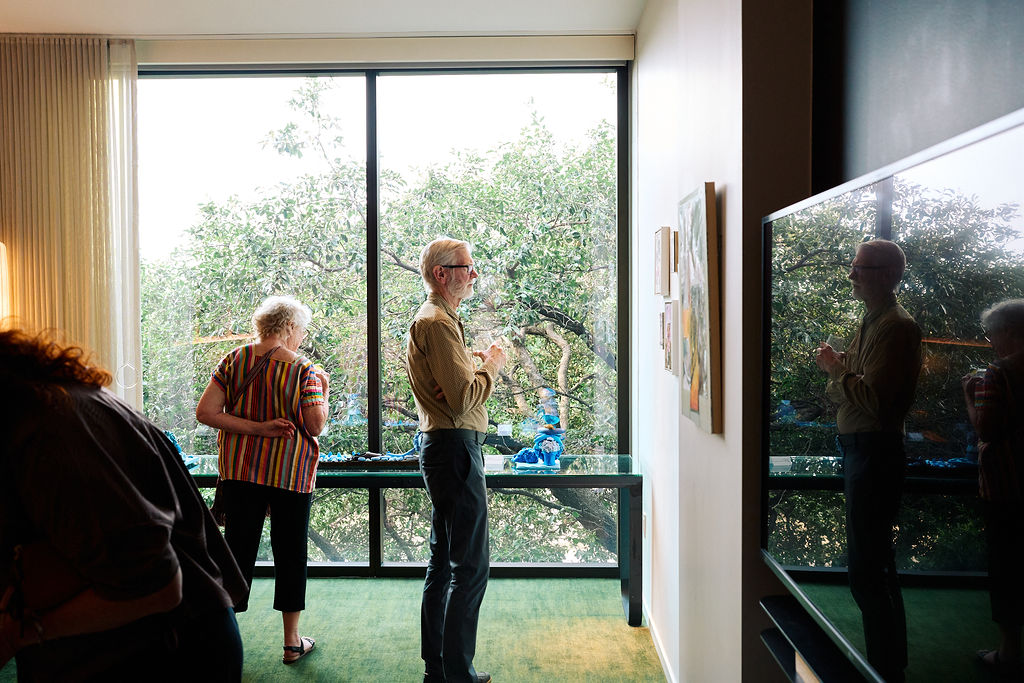 Guests view artwork inside a hotel room transformed into a gallery