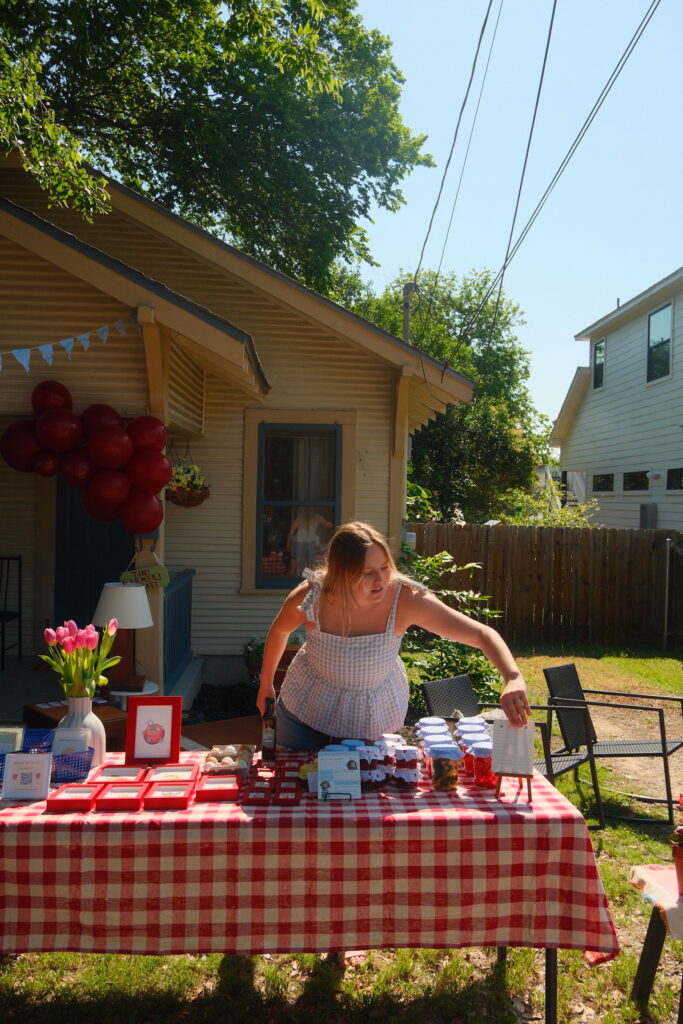 Hannah Gustafson, founder of Tiny Farmer’s Market, sets up her booth at the market in her front yard in Austin.