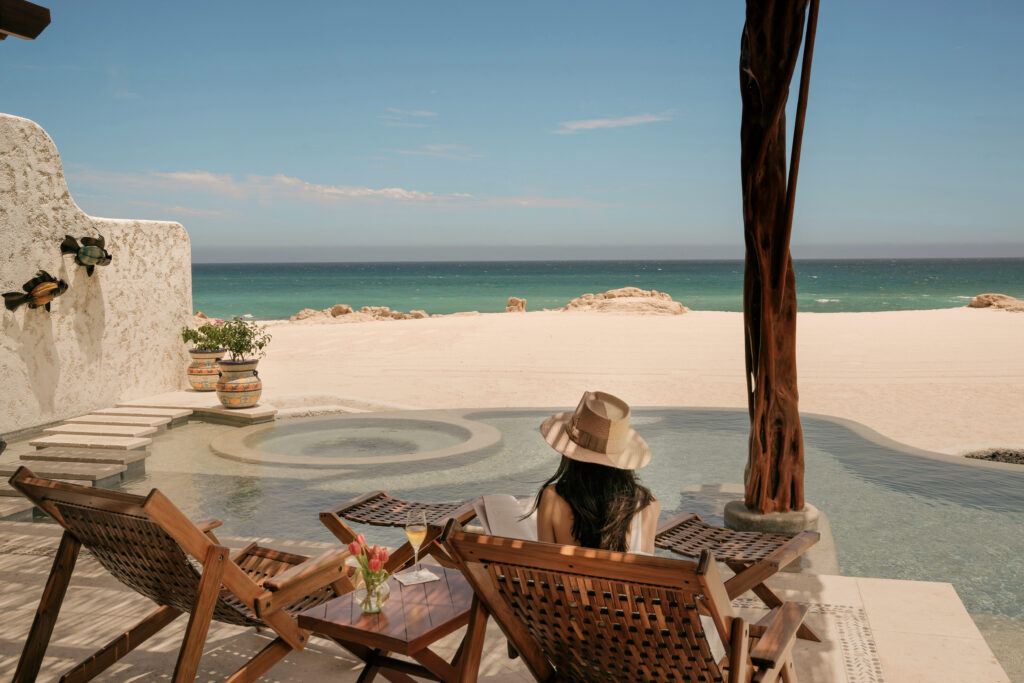Woman sits in private cabana on the beach in Los Cabos, Mexico.