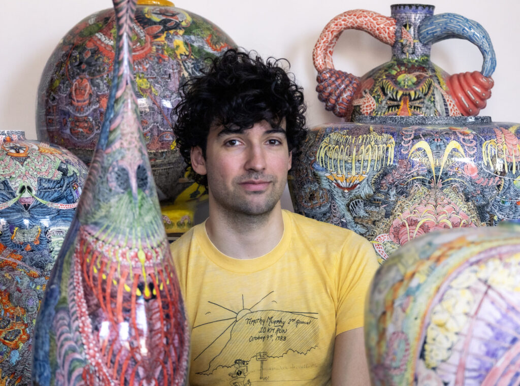 Charlie Hyman poses with works from his exhibition “Flat Earth,” on view through May 16 at Ivester Contemporary.