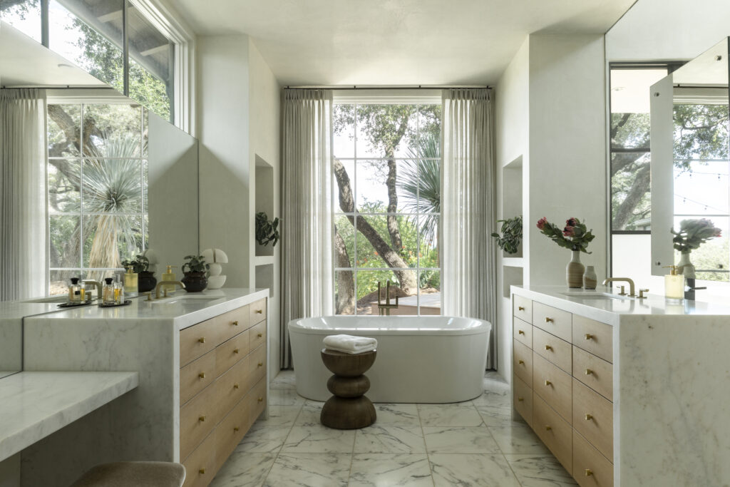 The primary bathroom in a Tarrytown home redesigned by Mark Cravotta of Cravotta Interiors continues the home’s refined material palette with a calm, spa-like feel.