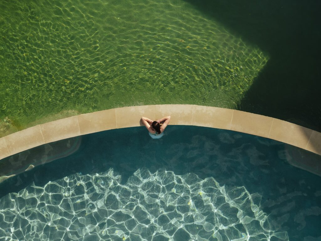 Woman soaking in the pool at Ottine Mineral Springs.