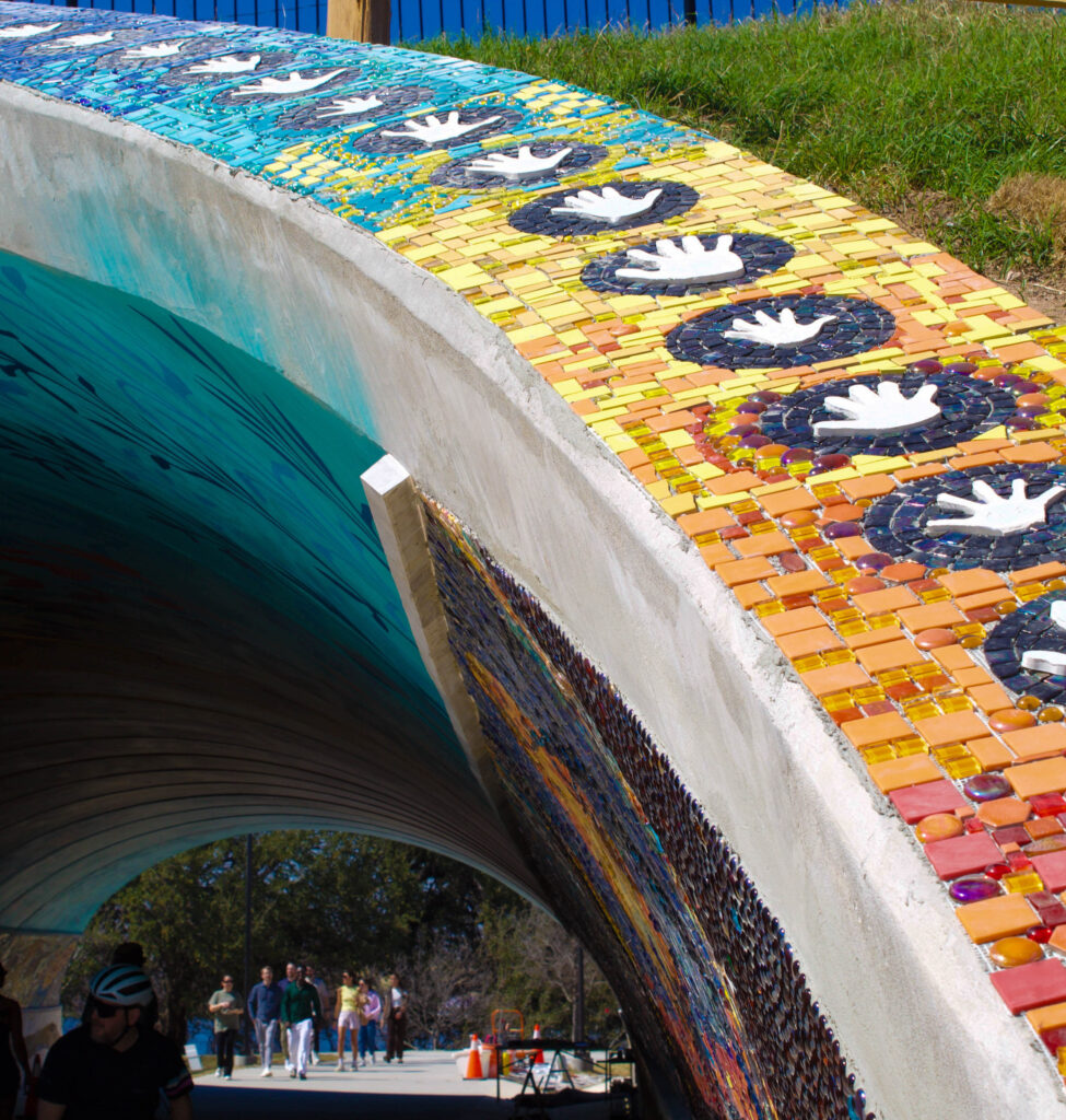 Handprints contributed by local residents frame the tunnel’s entrances, emphasizing the project’s community-driven spirit.