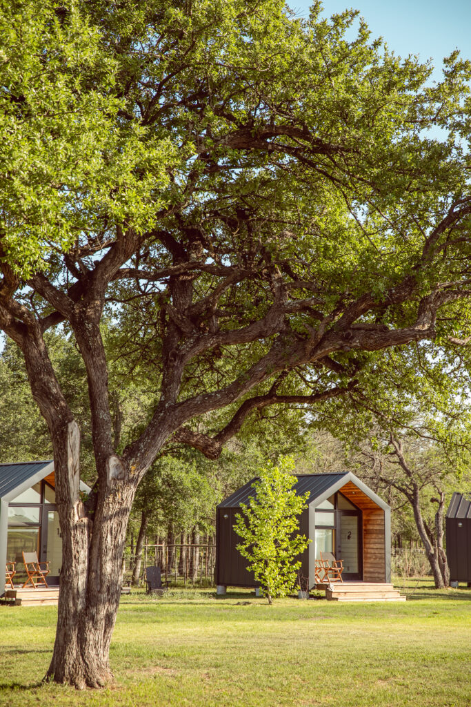 Small, modern cabins on a grassy farm at Rancho Moonrise.