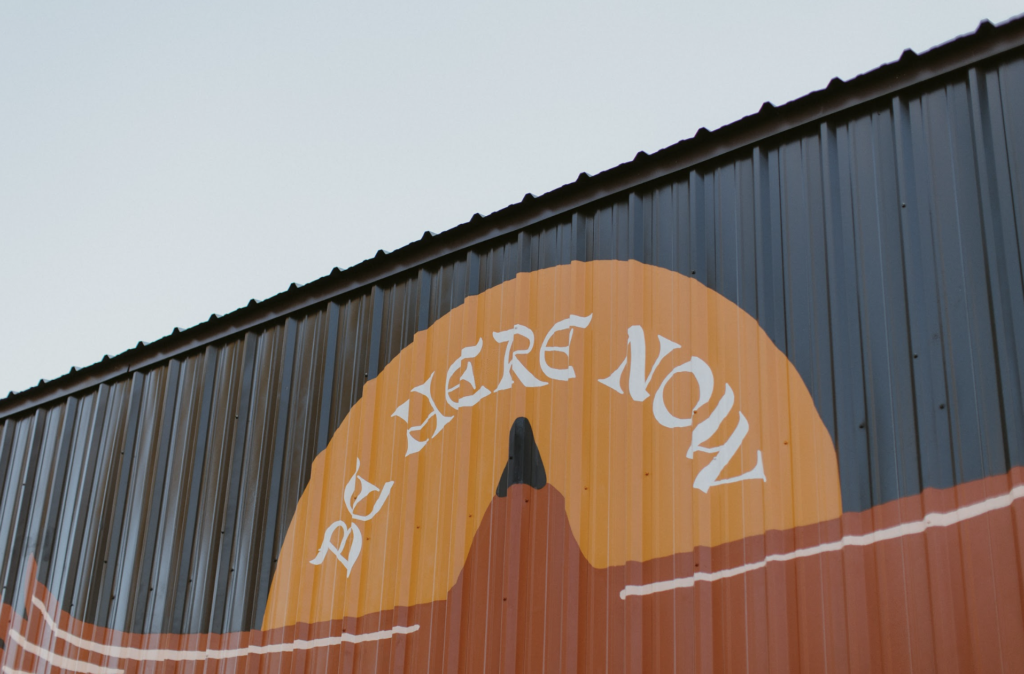 mural that says "Be Here Now"