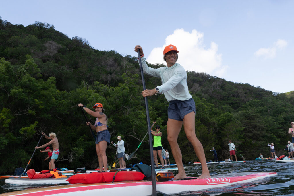 Carey Kepler, center, paddles with other participants on Lake Austin during Flatwater’s 17th annual Dam That Cancer fundraiser