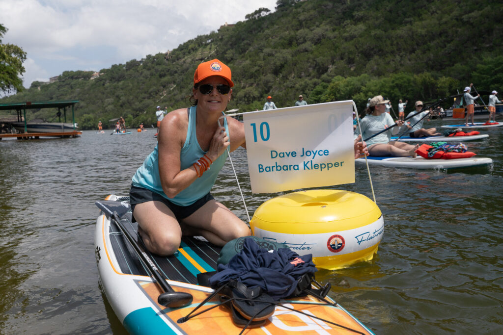 Katie Joyce paddles on Lake Austin during Flatwater’s 17th annual Dam That Cancer fundraiser in support of mental health therapy for people impacted by cancer.