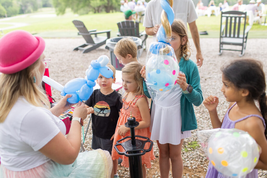 Silly Sparkles provides face painting and balloon art during the Muny Cup and 19th Hole Party at Lions Municipal Golf Course in Austin on May 8.