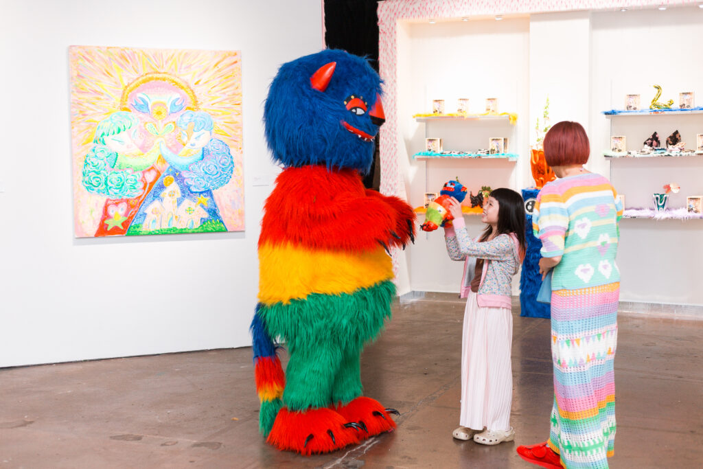 Guests pose with Mr. B Baby’s signature piñata-inspired character, “Chucho,” during the opening reception for “Monsters.” (Photo courtesy of WCC)