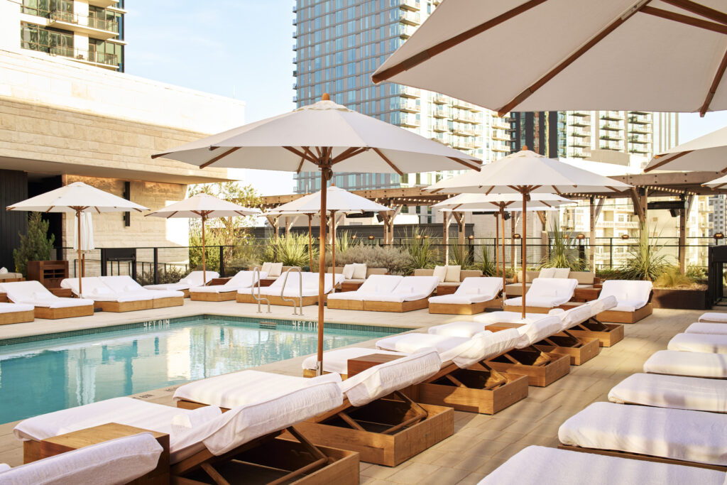 white pool umbrellas line the city rooftop pool at 1 Hotel Austin downtown