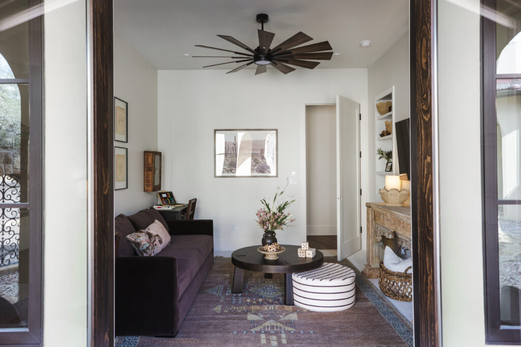 A vintage rug and carved stone fireplace give Casa Zia’s movie room a relaxed place for family and friends to gather. (Photo by Brittany Dawn Photography)