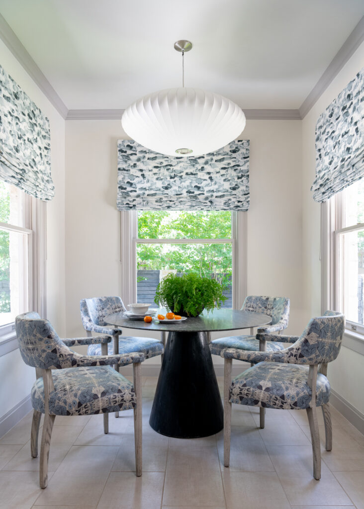 Patterned chairs and Roman shades bring a softer touch to the light-filled dining area. (Photo by Michael Hunter)