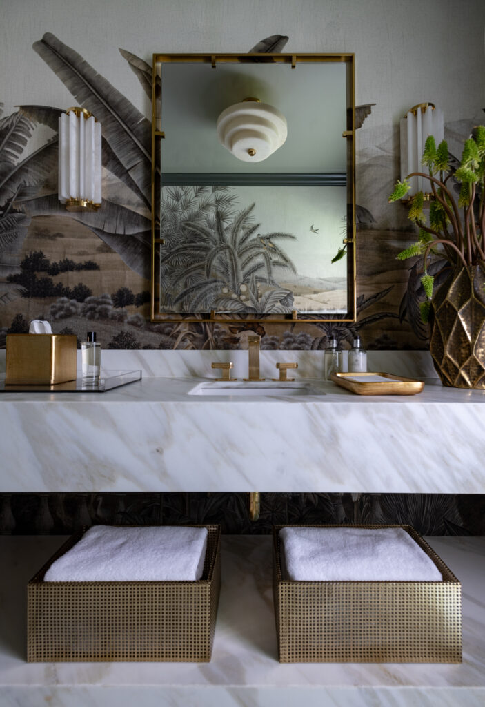 A detailed landscape mural wraps the renovated powder bath, while dark trim and a marble vanity bring the design into focus. (Photo by Michael Hunter)