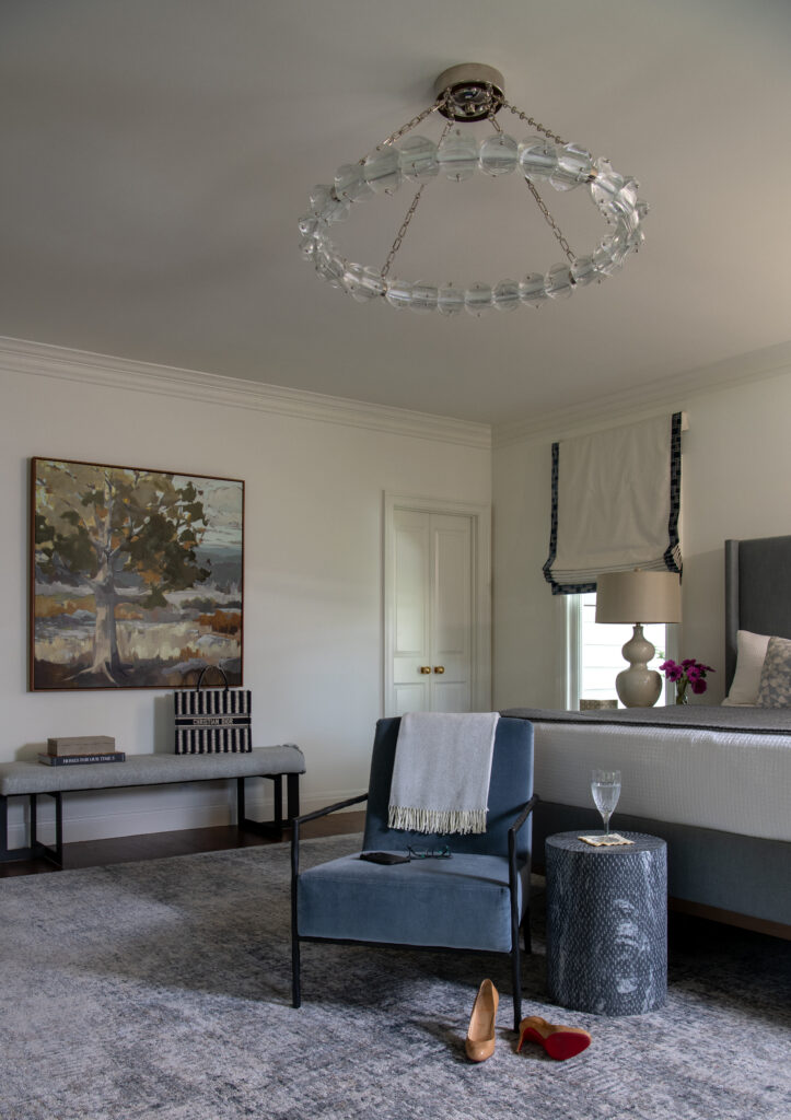 Hudson House gave the bedroom a quieter palette, with blue seating and a landscape painting adding color.(Photo by Michael Hunter)