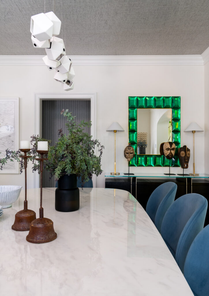 In the formal dining room, a sculptural light fixture and vivid green mirror give the historic home a contemporary edge. (Photo by Michael Hunter)