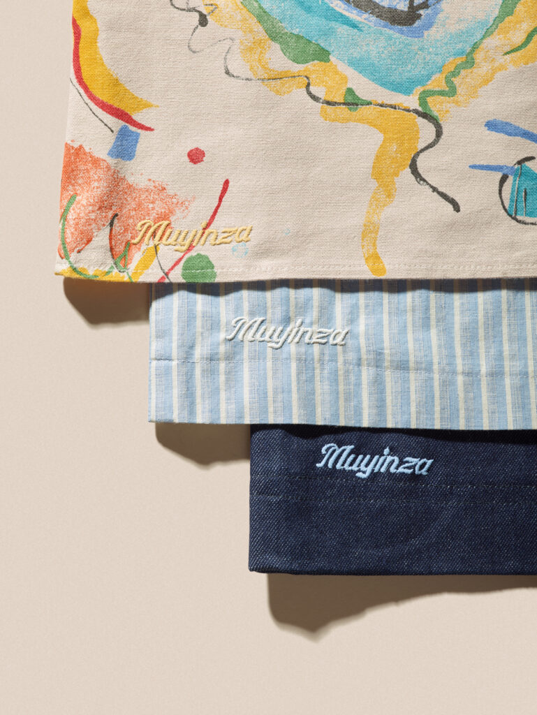 A finished piece bears the embroidered "Muyinza" label, added by Austin artist Kenny Pursley.