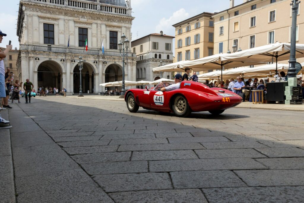 A racecar driving through Piazza della Loggia during the 1000 Miglia historic race. (Photo by Marco Piccinelli)