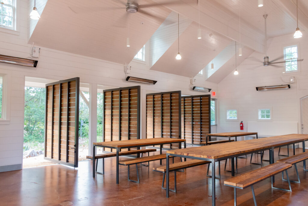Seating inside the restored carriage house includes custom tables made by Austin furniture maker Brent Clifton using wood salvaged during the renovation.
