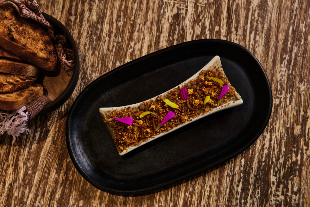 Escuela Fino’s bone marrow mousse is served with puffed grains, curtido crumble and grilled birote.