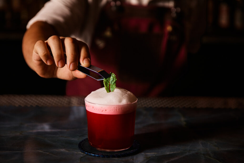 The Root Awakening at Escuela Fino combines gin, house-made beet amargo, lemon and ginger, topped with apple air.
